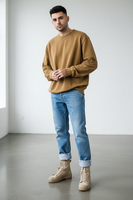 TRAFORI men's light wash denim jeans with cuffed hems, paired with a tan sweatshirt and beige boots.
